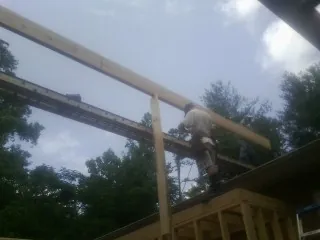 Carpenter setting a ridge beam over a new addition frame — Ice Dam Removal by Roofing Brothers in Bosler