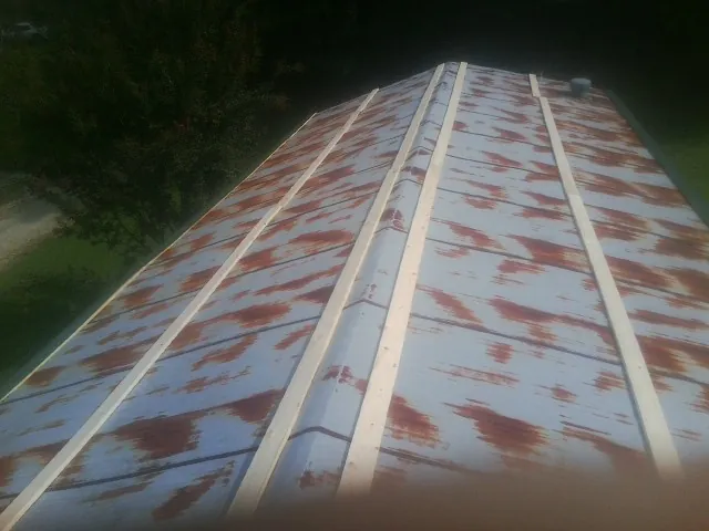 Rusted metal roof panels with new wood purlins before replacement — Storm Damage Roof Repair in Bosler by Roofing Brothers