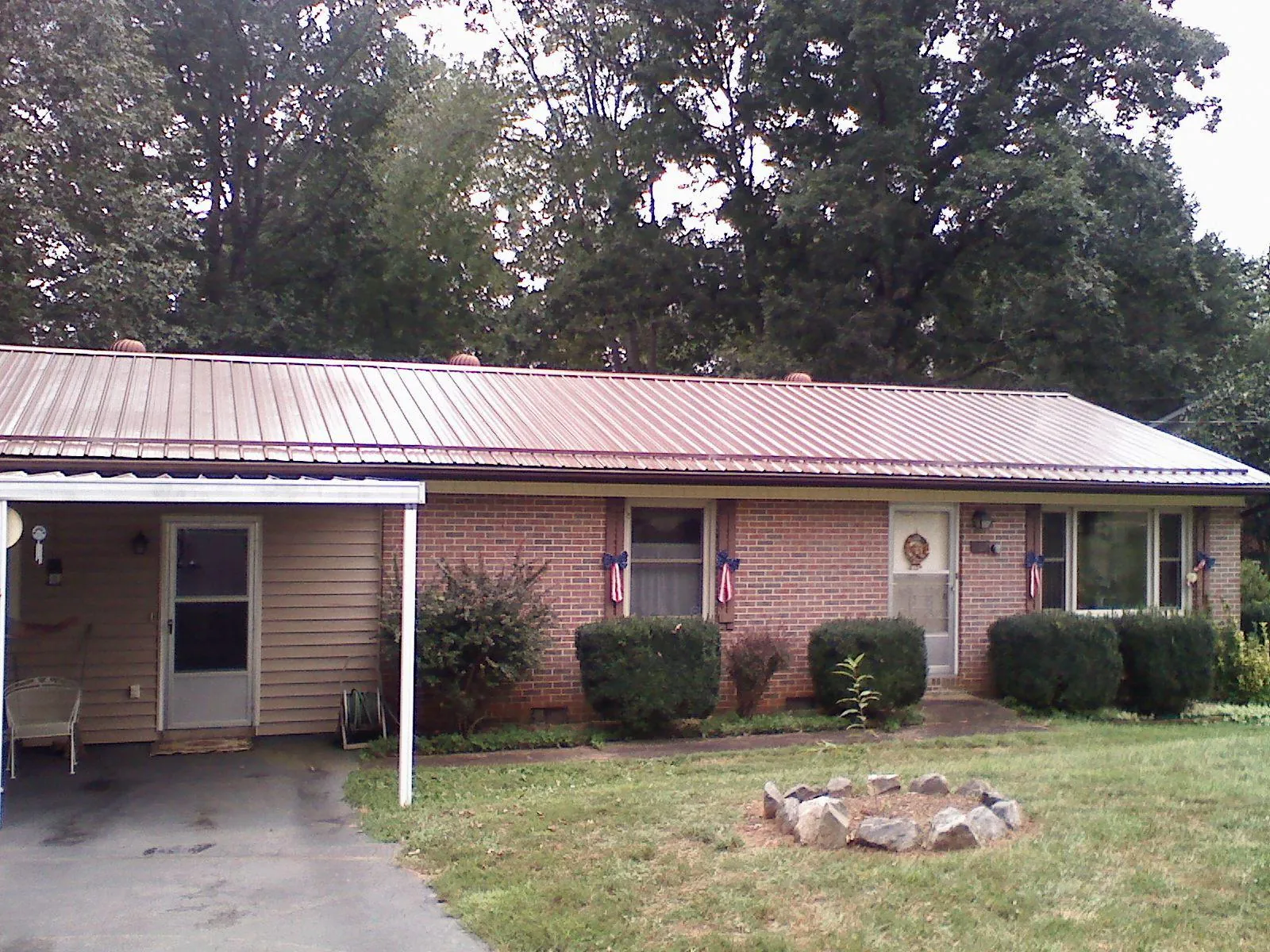 Bronze metal roof and carport on a brick ranch home — Roof Repair work by our crew in Bosler